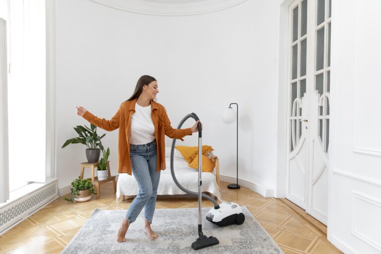 full-shot-smiley-woman-vacuuming-carpet